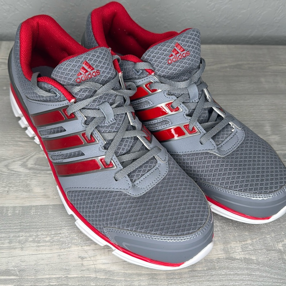 Mens stylish gray and red athletic sneakers. Perfect for sports and casual wear.